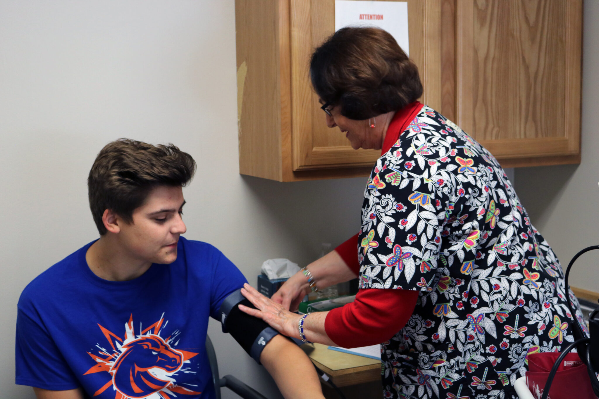 Volunteer nurse checking a patient's blood pressure at the Friendship Clinic